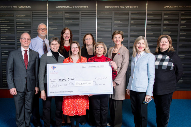 Dr. Timothy Olson, Rick Saillard, Dr. Marysia Tweet, Dr. Patricia Best, Dr. Sharonne Hayes, Dr. Dr. Patricia Pellikka, Toni Sauber Holding check: Jan Saillard, Kayla Karan and Susan Edelman Ceremonial Check aPresented to Mayo Clinic SCAD Research Program